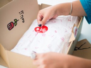 person sticking sticker on box